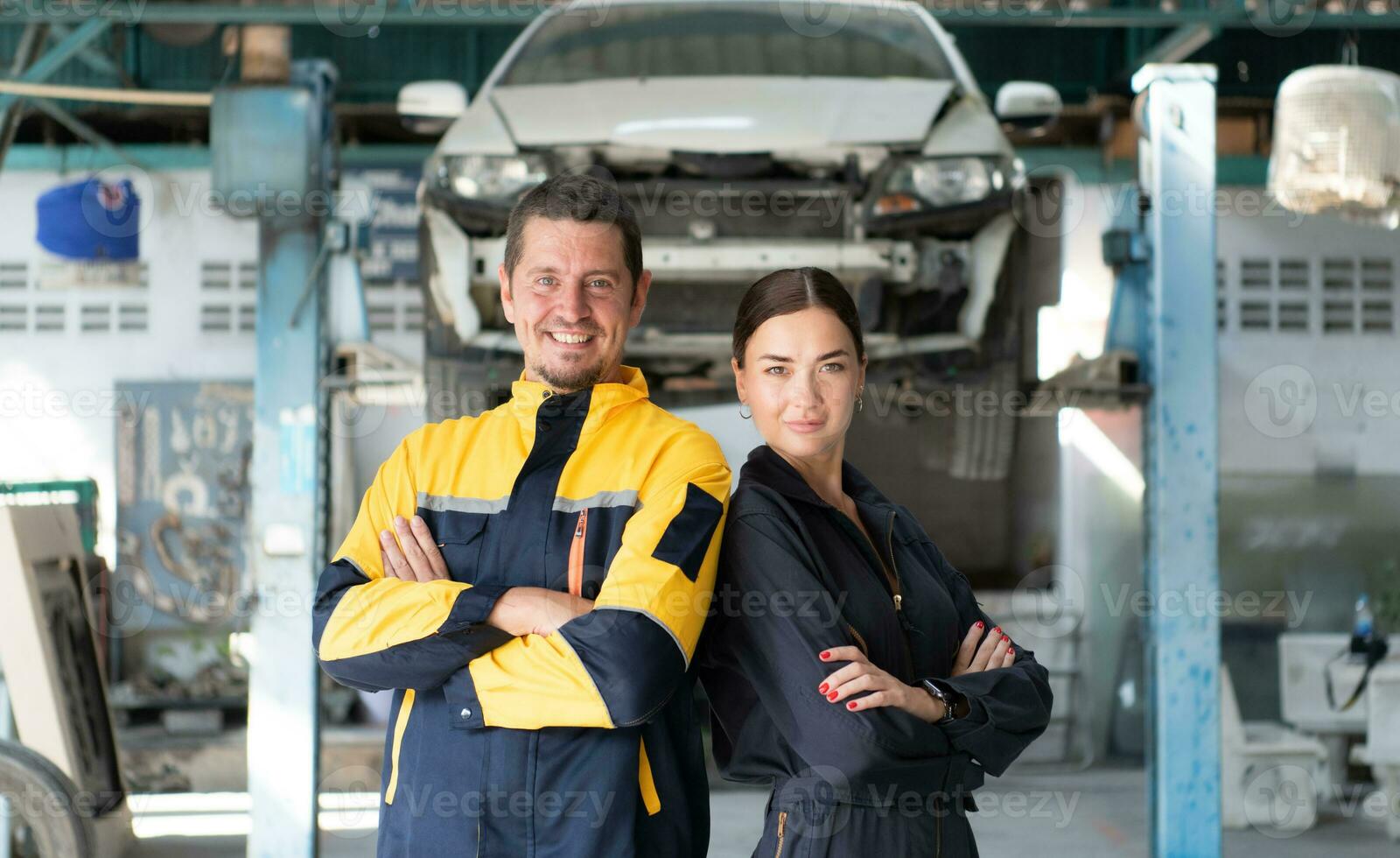 Portrait of engineer and auto mechanic with working on engine repairs in car garages photo