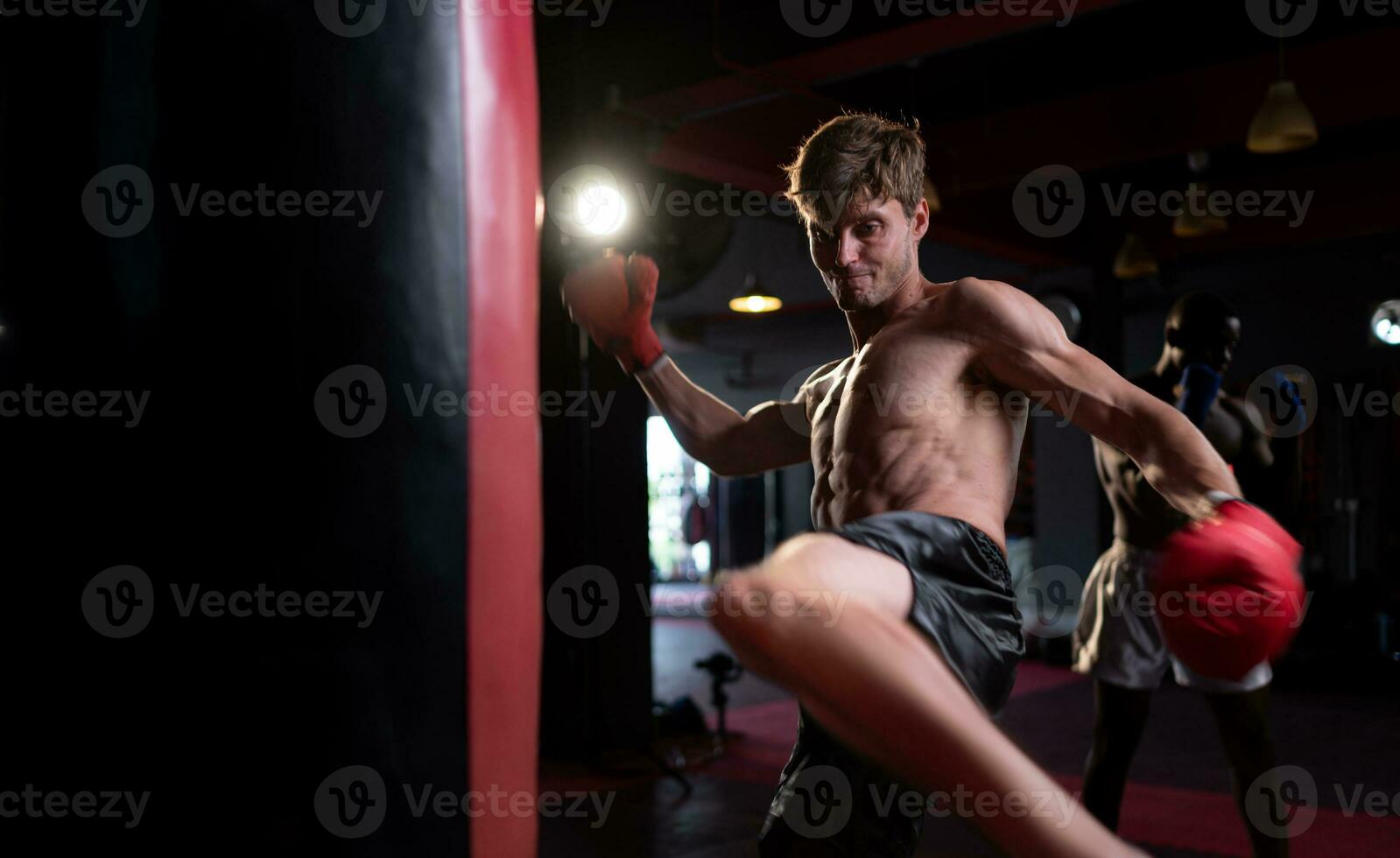 Portrait of boxers must practice their kicking and punching skills with punching bag. To build strength and power of kicking and punching. photo