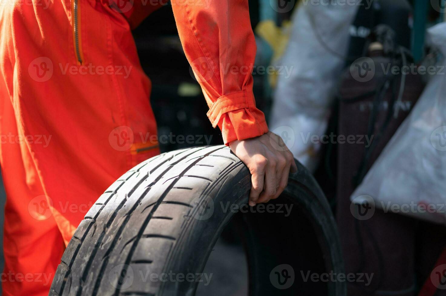 A car mechanic inspects the condition of a car tire before placing it on a vehicle. photo
