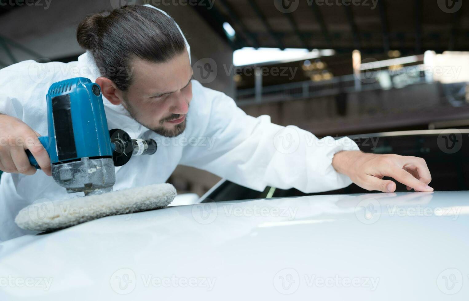 auto mecánico utilizar un eléctrico pulidora a polaco el seco coche pintar. después paso el pintar desde el coche pintura habitación foto