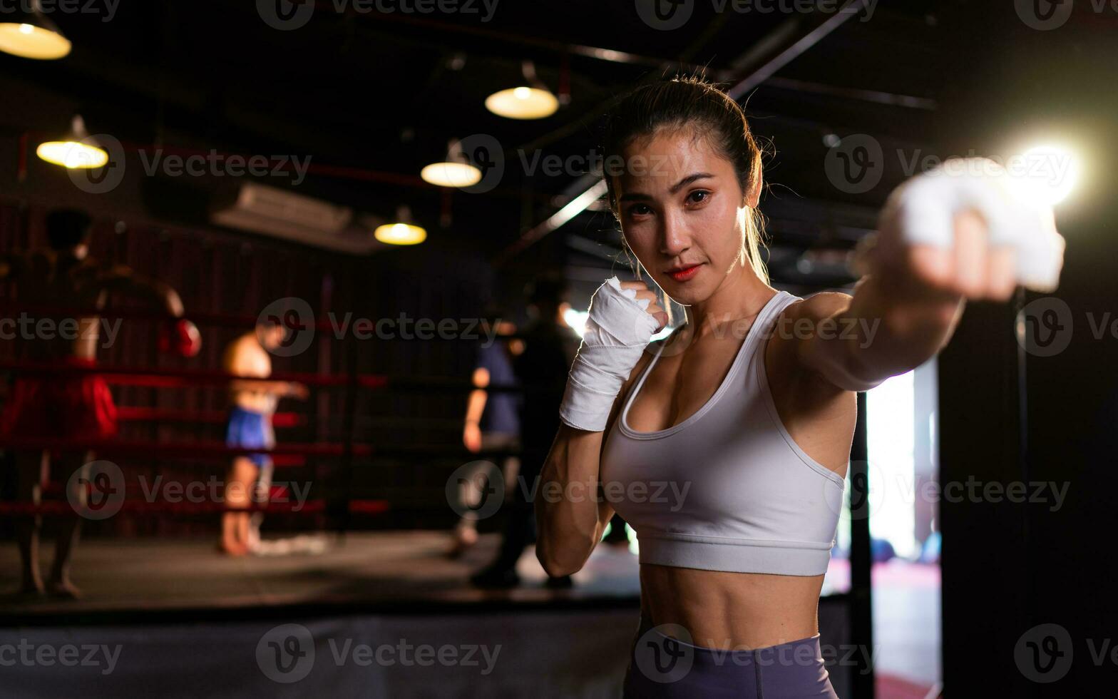 Portrait of woman learning Muay Thai to build up the strength of the body and use it for self-defense. Are using hand wraps before putting on boxing gloves for boxing photo