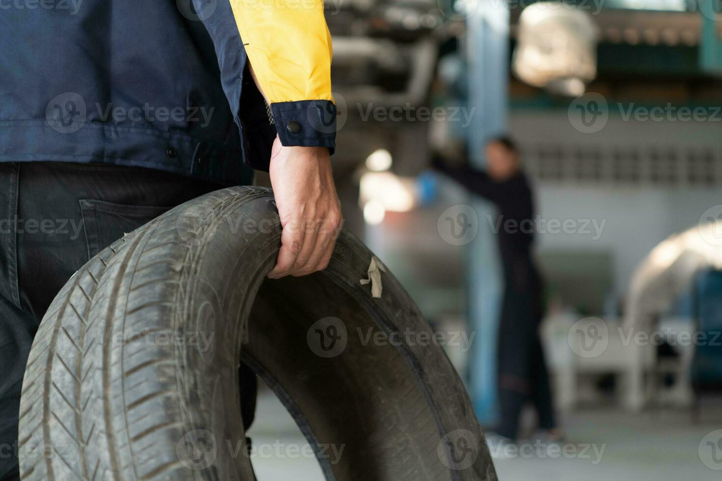 A car mechanic inspects the condition of a car tire before placing it on a vehicle. photo