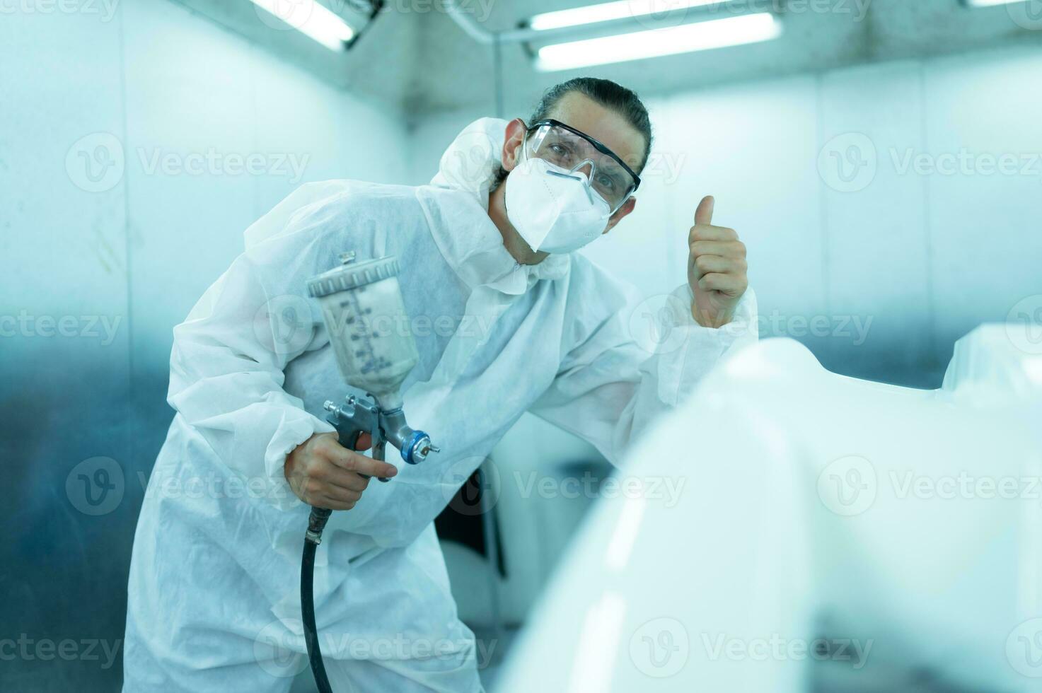 Auto mechanic in car spray room Inspecting the paint sprayed into the front bumper of the car that the pigment is complete, beautiful, harmonious with the original color of the car photo