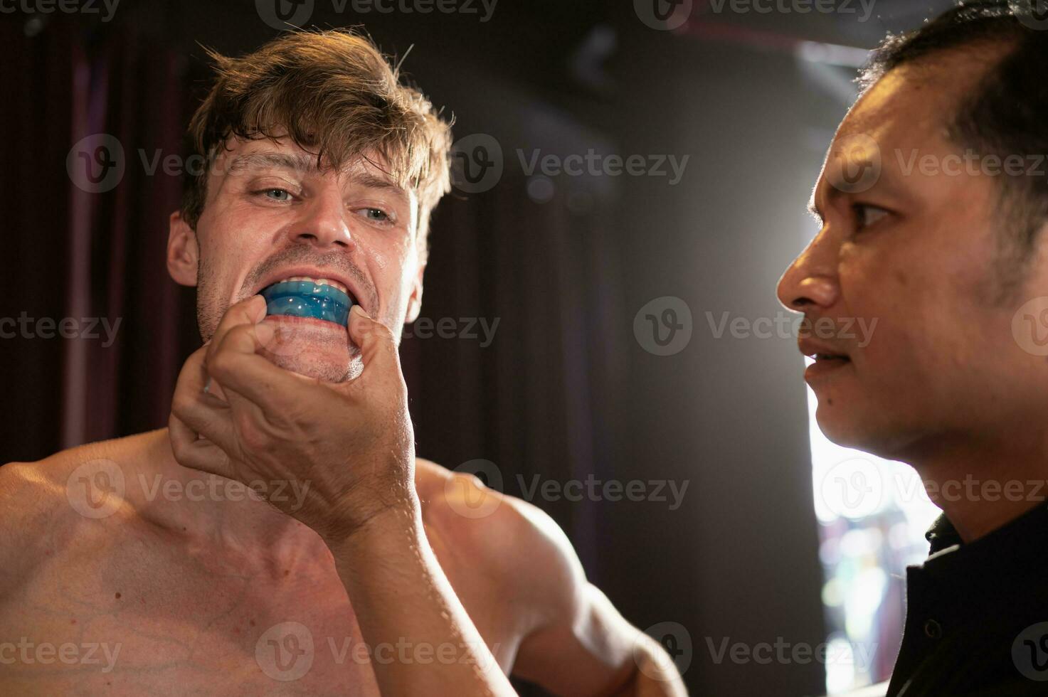 The boxer must wear a tooth collar before the fight to prevent the risk of injury from teeth clashing when punched in the chin or face, Muay Thai, Thai martial arts. photo