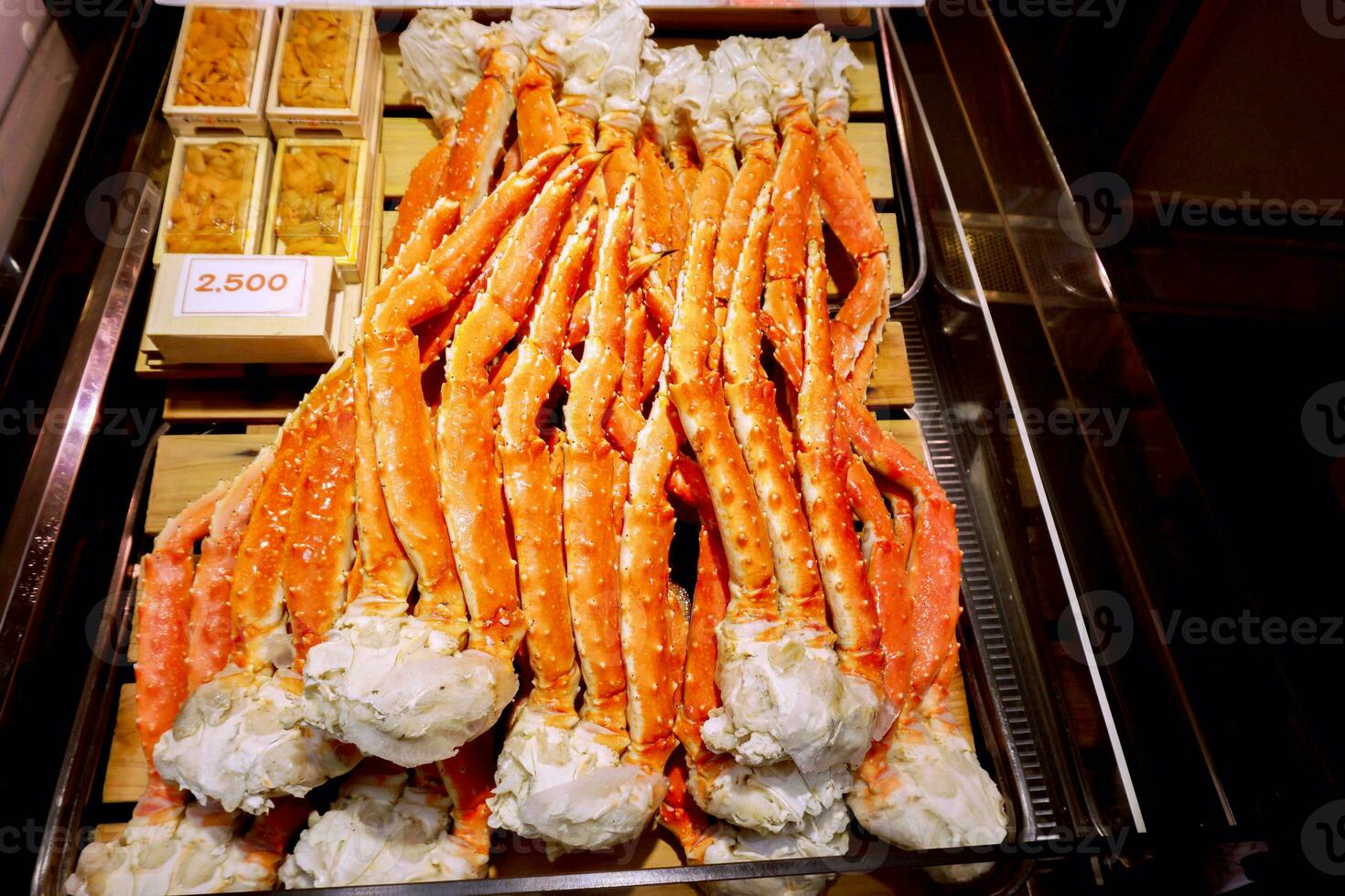 Closeup lots of burned king crab legs ready to serve for customer with labels price in the box at Kuromon market, Osaka, Japan. photo