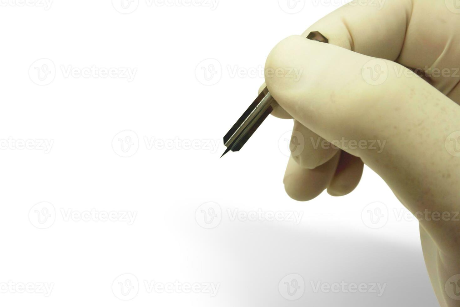 Closeup and croup hand of doctor in white medical glove and shadow holding blood lancet isolate on white background and make with paths. photo