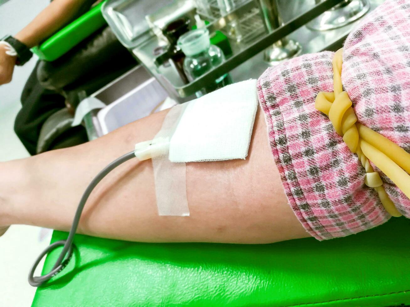 Image of syringe and the hose was pierced on the arm of blood donor. Blood donation is another contribution to other patients' lives. And in Thailand is considered a merit. photo