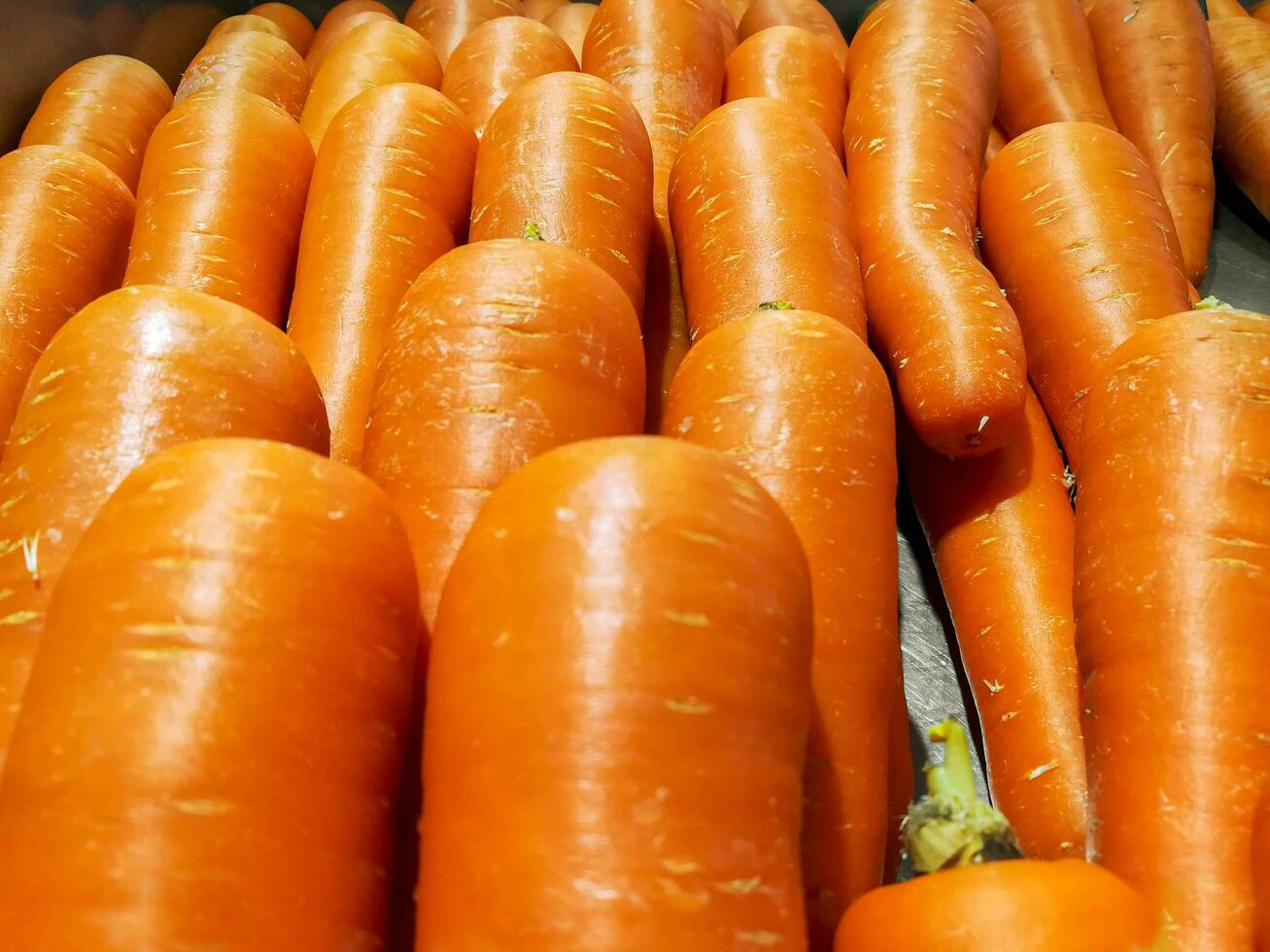 Closeup carrot laying lined up on the vegetables's shelf in the market. photo