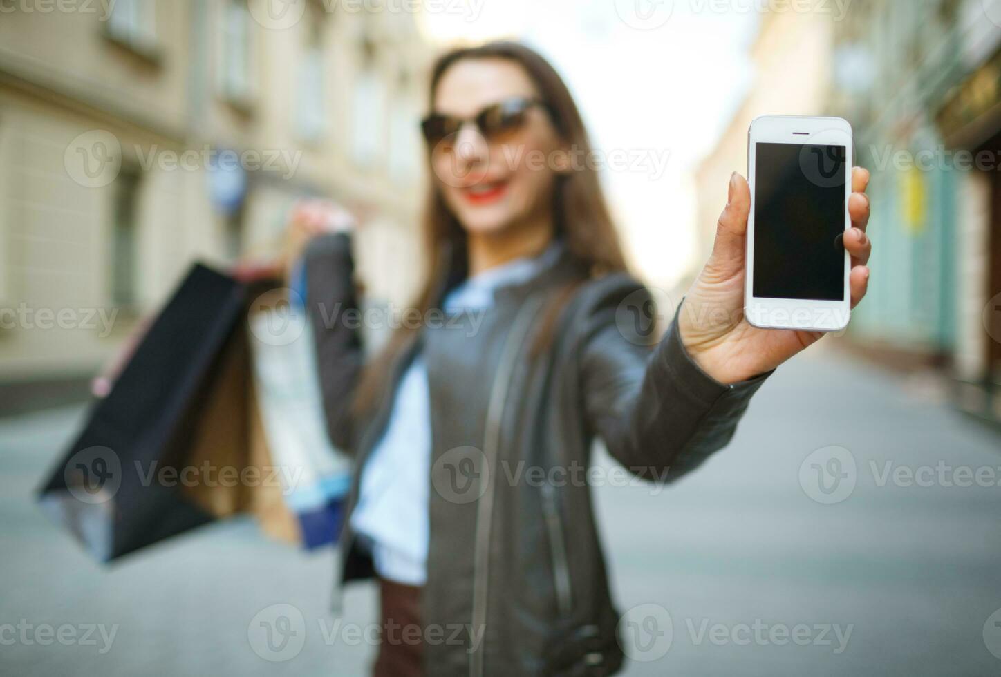 Online shopping concept -l woman with shopping bags and smart phone in the hands photo