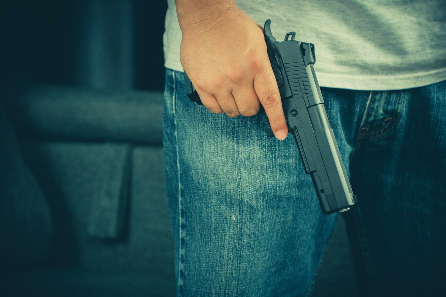 Men wearing t-shirts, jeans Standing holding a gun in the house photo