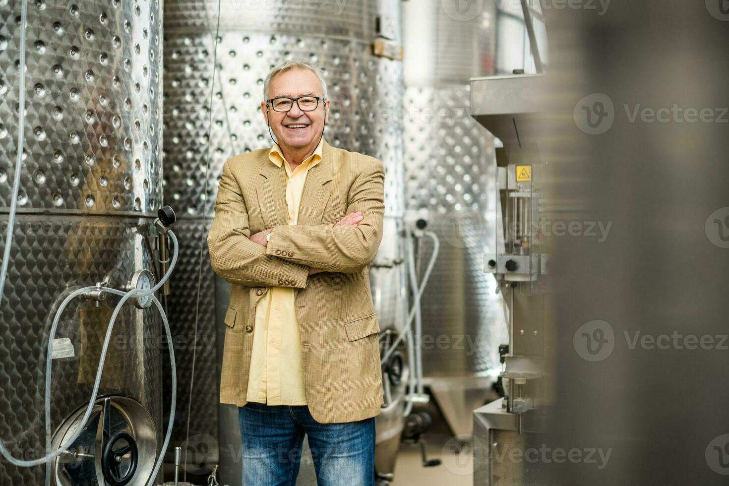 Happy senior man who owns a winery. Industry wine making concept