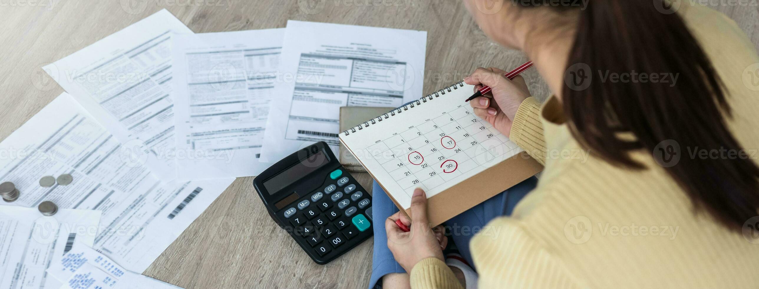 Top view owe, mortgage asian woman, female sitting on floor home, stressed calculate expense from bills, no money pay in mark circle deadline on calendar.Debt, bankruptcy or bankrupt person concept. photo