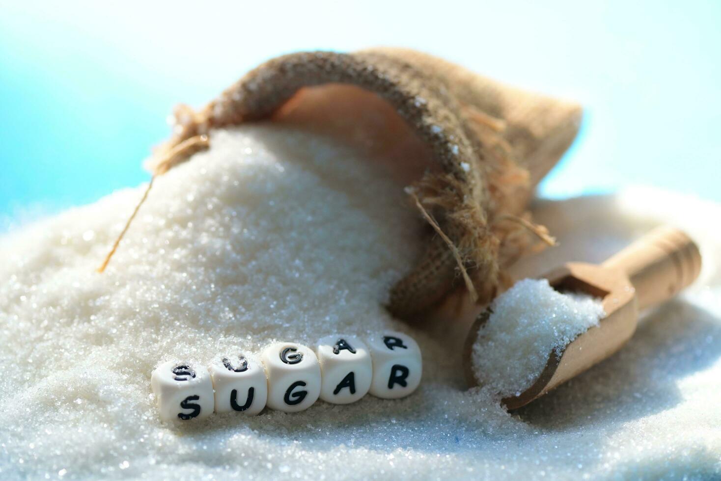 blanco azúcar para comida y dulces postre caramelo montón de dulce azúcar cristalino granulado, azúcar en saco y de madera antecedentes foto