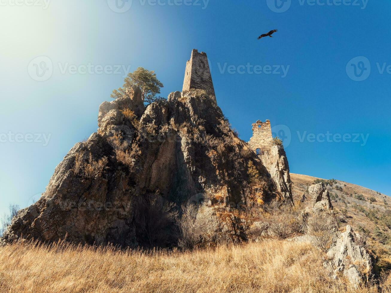 Sunny afternoon in the Caucasus mountains. Medieval tower complex Vovnushki, one of the authentic medieval castle-type tower villages, located on the extremity of the mountain range in Ingushetia photo