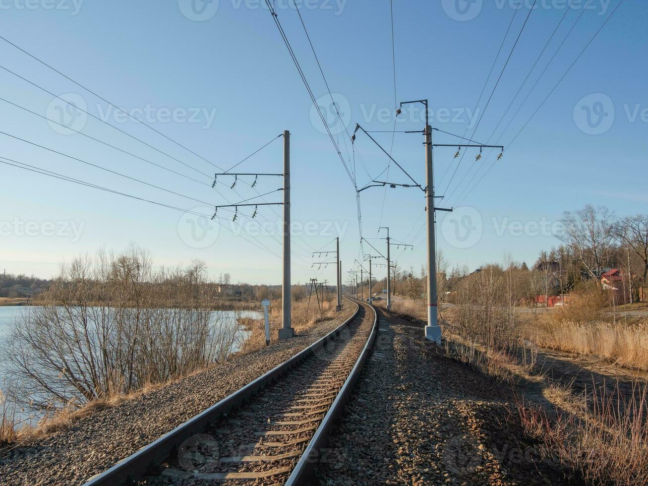 Empty railway track, single rail. Railway track turns and twists between out of focus hills background. Empty rounding and turning single track of railways. photo