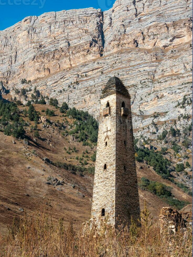Sunny afternoon in the Caucasus mountains. Medieval tower complex Nii, one of the authentic medieval castle-type tower villages, located on the Jeyrakh district in Ingushetia, Russia. photo
