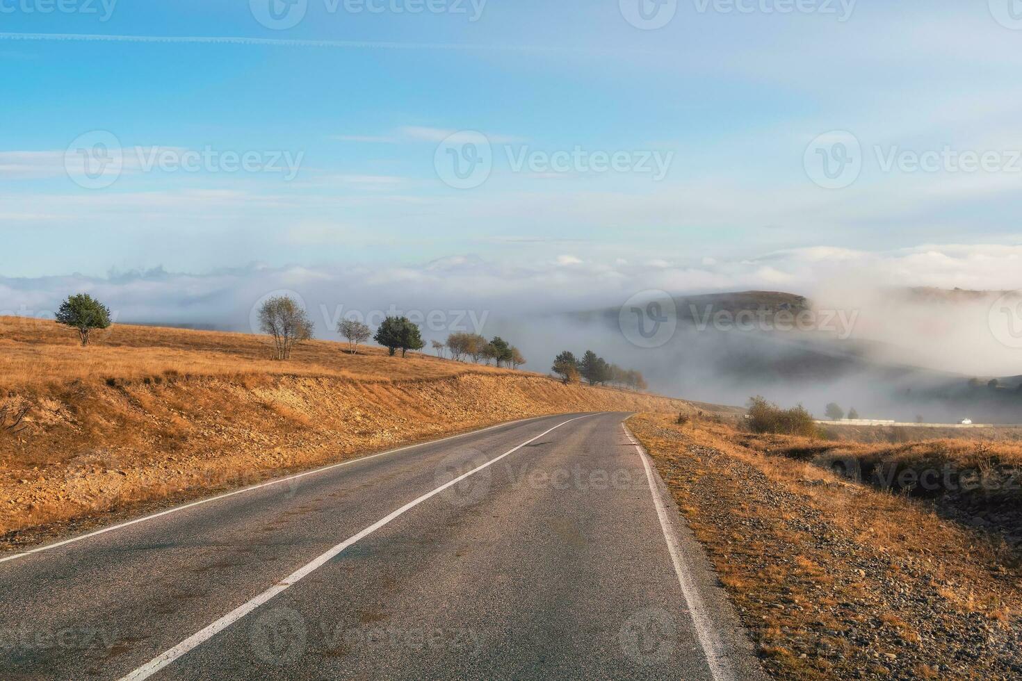 vacío Mañana autopista mediante el pasar en grueso niebla. hermosa asfalto autopista, autopista, autopista mediante de caucásico paisaje montañas colinas a frío clima en medio octubre. foto