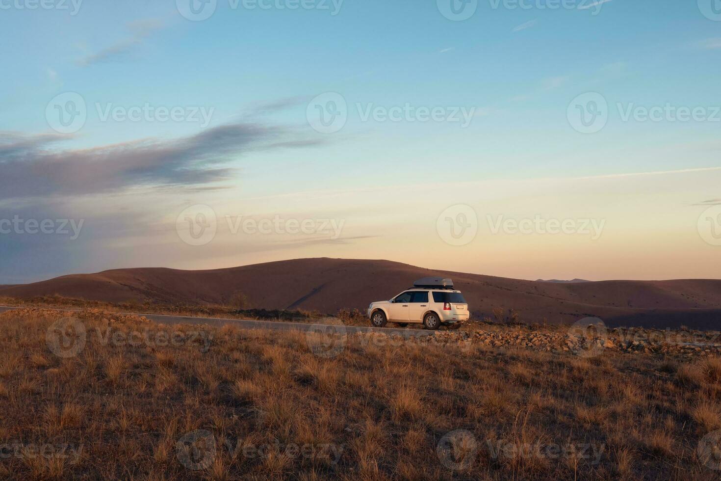 blanco coche suv estacionado cerca escénico ruta la carretera en otoño Cáucaso paisaje. natural Cáucaso punto de referencia y popular destinos equipaje maletero caja montañoso en coche techo estante. foto