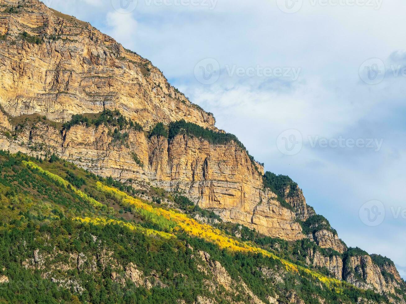 Beautiful mountain landscape with red rounded rocks. Big rock formation, different rock formations and soil layers. Distant mountain plateau. North Ossetia. photo