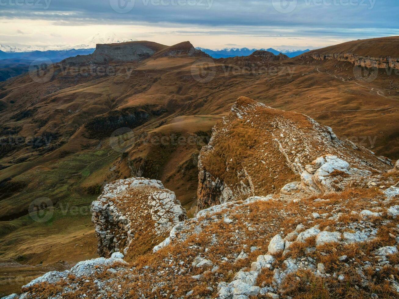 amanecer ver de bermamyt meseta rocas montañas en el borde de un acantilado en el distancia en dramático Mañana. atmosférico paisaje con siluetas de montañas. karachay-cherkesia, Cáucaso, Rusia. foto