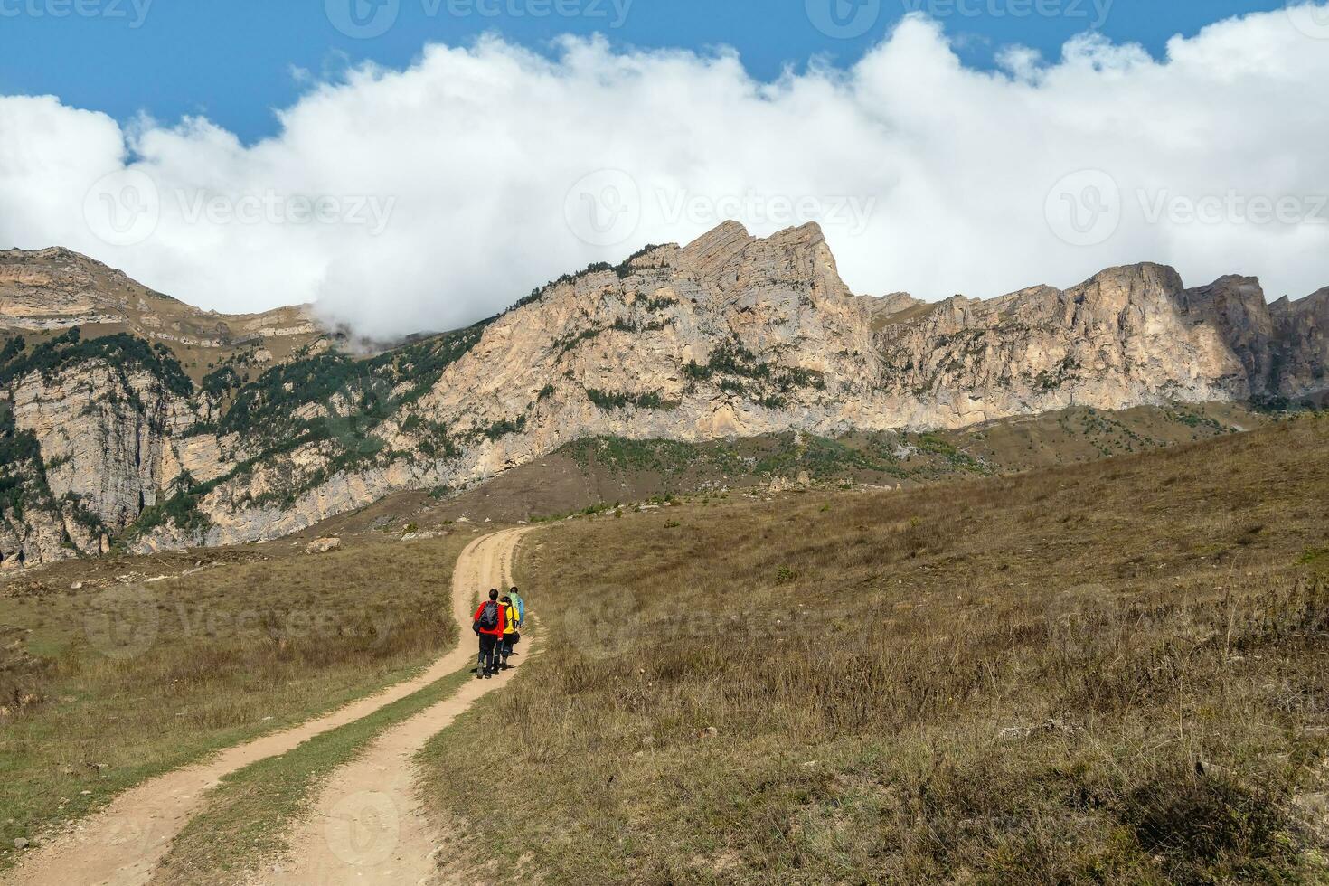 Walking and hiking trails in the mountain range in the sunny day. Family backpacker tourists hiking. Digoria. Caucasus Mountains. photo