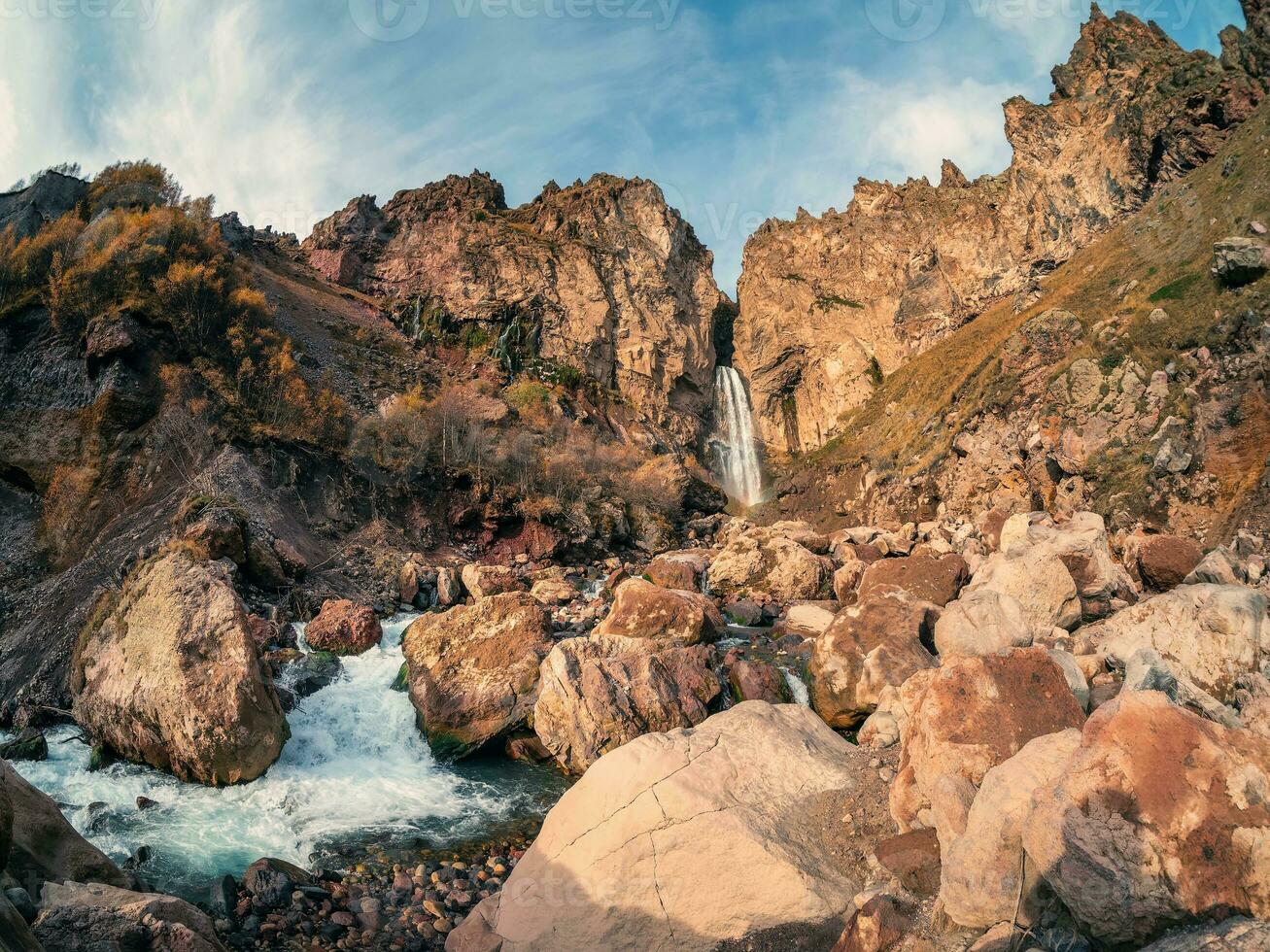 escénico otoño paisaje con vertical grande sultán cascada a montaña parte superior en Brillo Solar en el jila-su tracto. kabardino-balkaria. Rusia, Cáucaso. alto que cae agua en del Norte elbrus región. foto