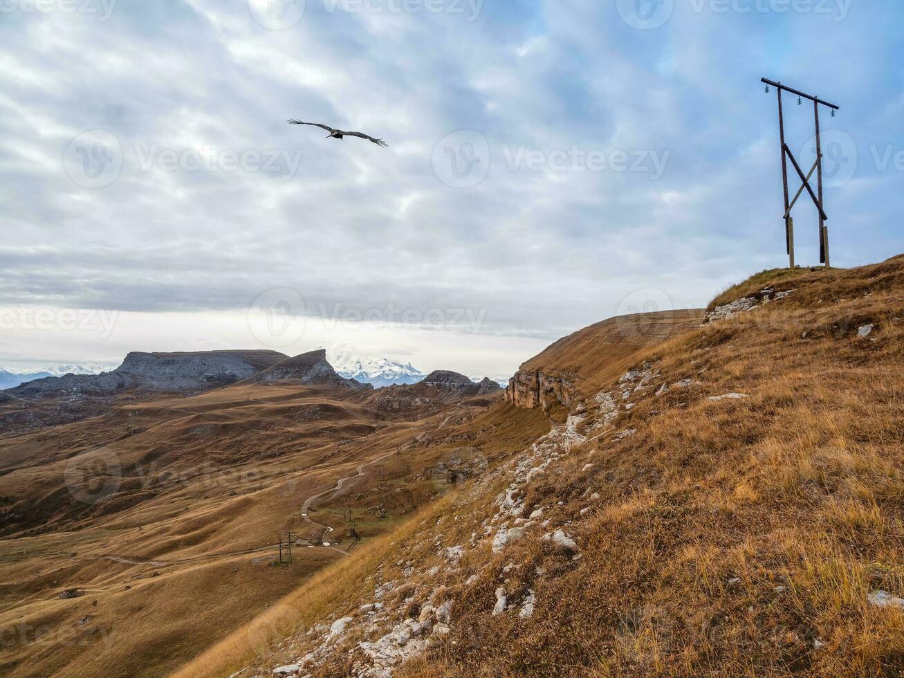 Soft focus. Beautiful high-altitude plateau with a telegraph pole on the background of the snow-covered Mount Elbrus.The Bermamyt plateau in Karachay-Cherkessia. photo