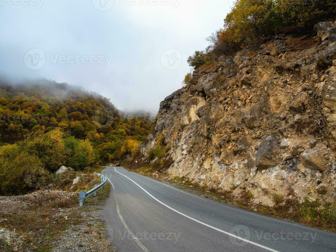 vacío Mañana autopista mediante el pasar en grueso niebla. hermosa asfalto autopista, autopista, autopista mediante de caucásico paisaje montañas colinas a frío clima en medio octubre. ingusetia foto