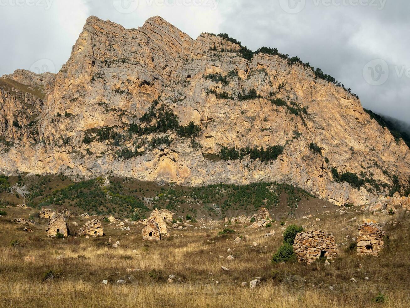 un tumba Roca ciudad debajo un grande roca. antiguo osetio familia criptas en el brumoso montañas. digoría región. foto