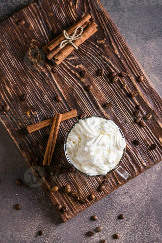 A cup of sweet Vienna coffee with whipped cream on a dark background top and vertical view photo
