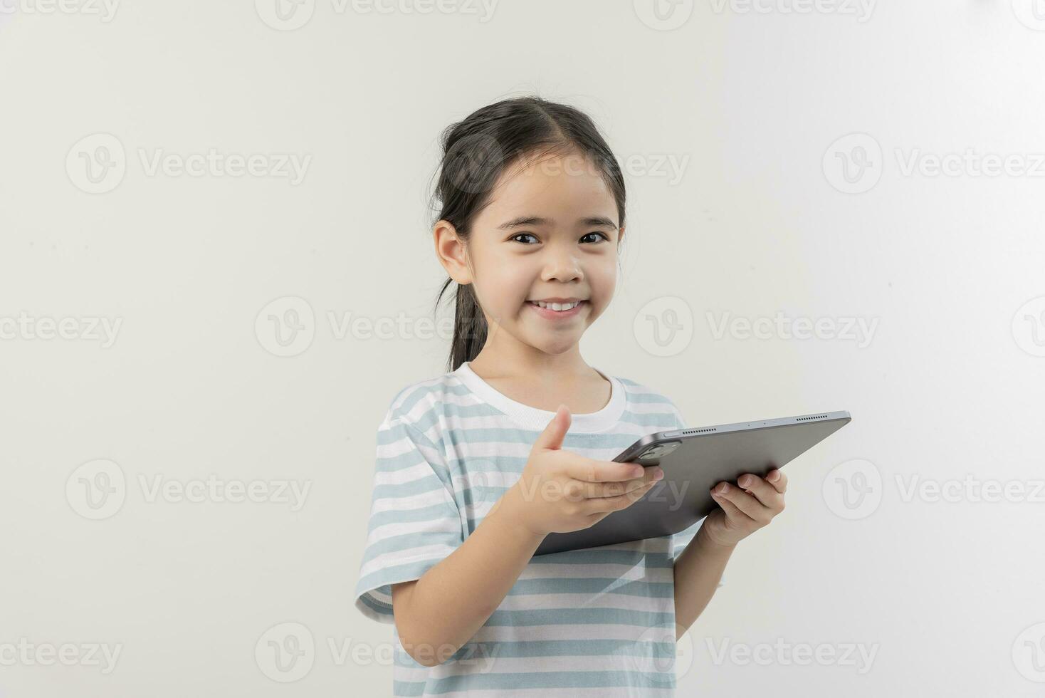 sonriente pequeño niña cosiendo y participación un tableta foto