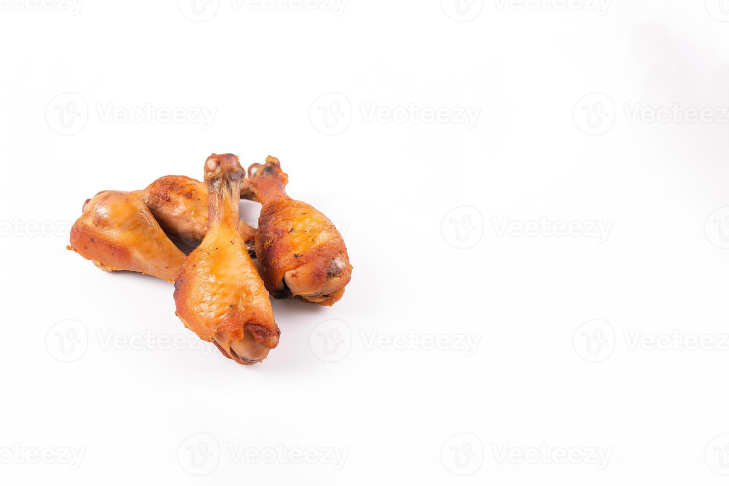 Delicious baked chicken drumsticks in honeymustard marinade isolated on white background with copy space. photo