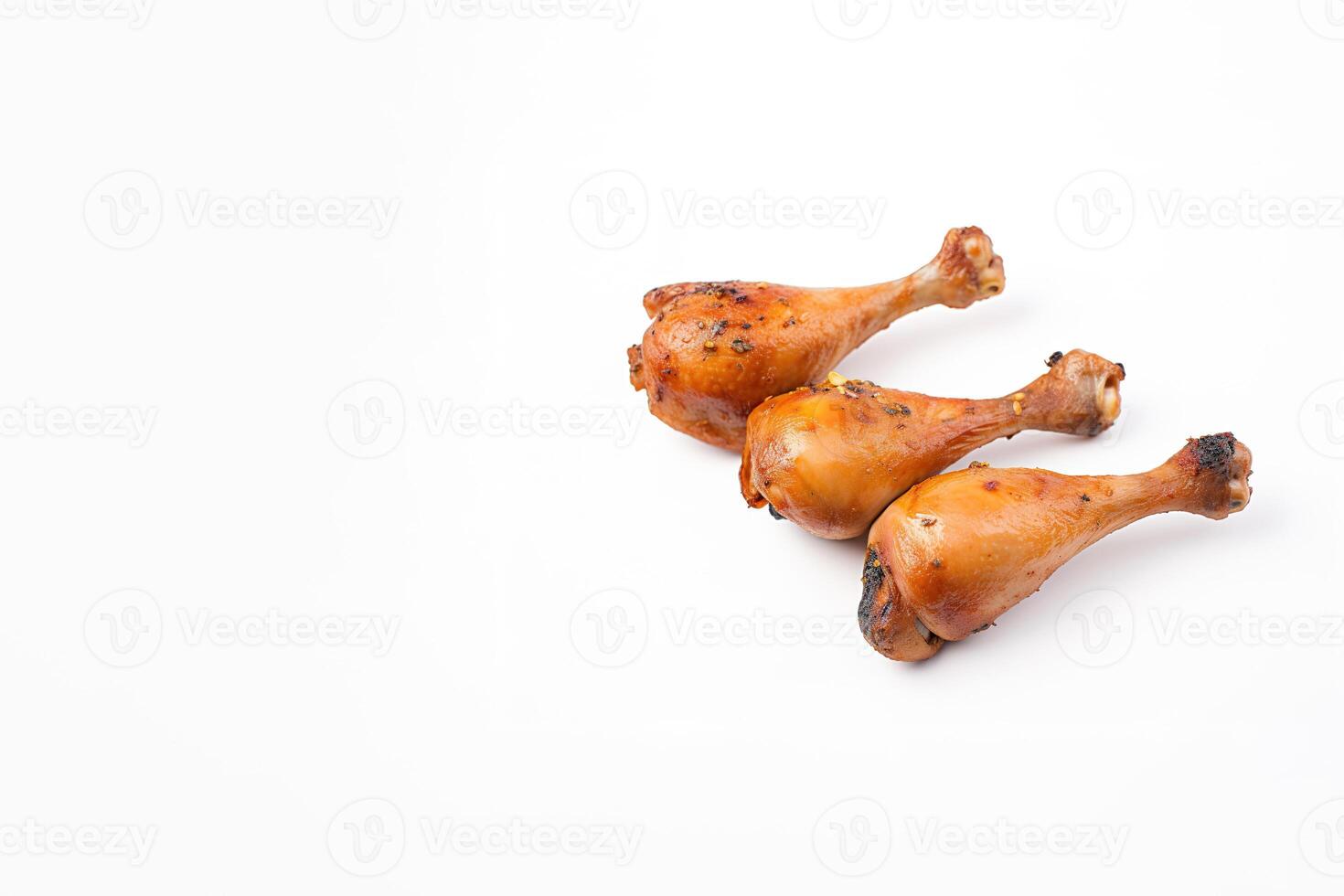 Delicious baked chicken drumsticks in honeymustard marinade isolated on white background with copy space. photo