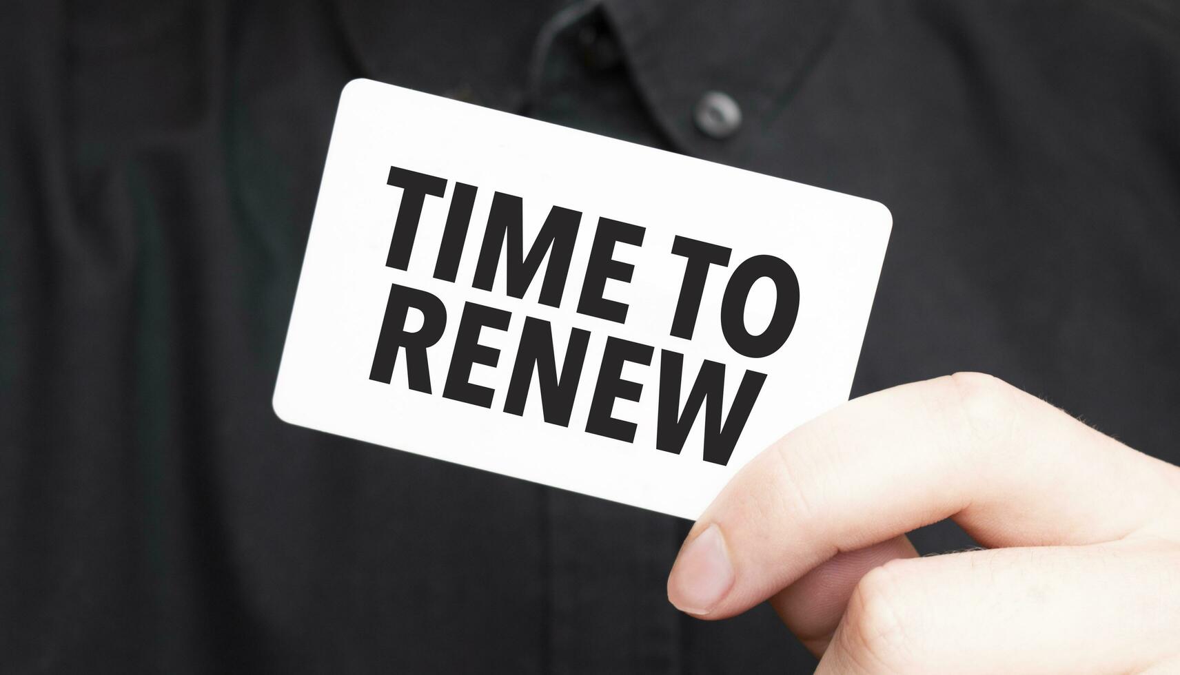 Businessman holding a card with text time to renew, business concept photo