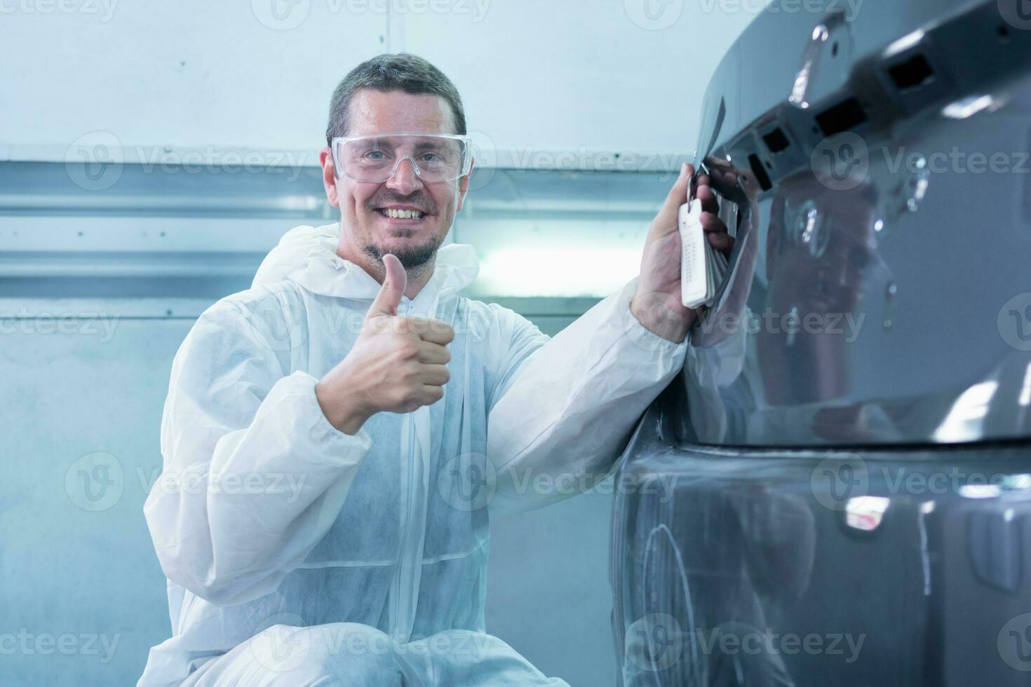 Worker man showing thumbs up, Mechanic painting car in chamber, Garage painting car service repair and maintenance photo