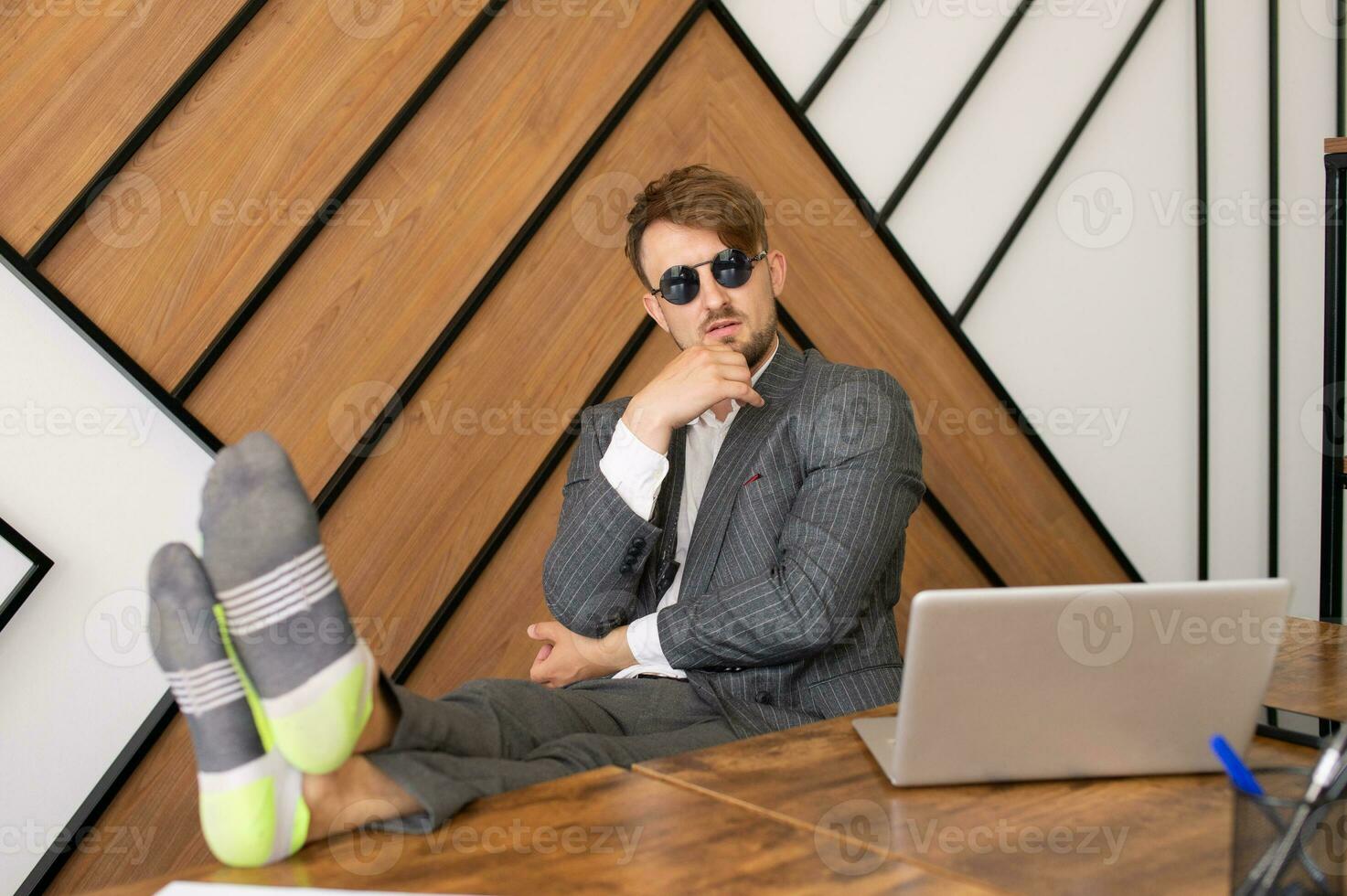 A lazy employee Sitting at a laptop With his feet on the table, A bored concept at work, photo