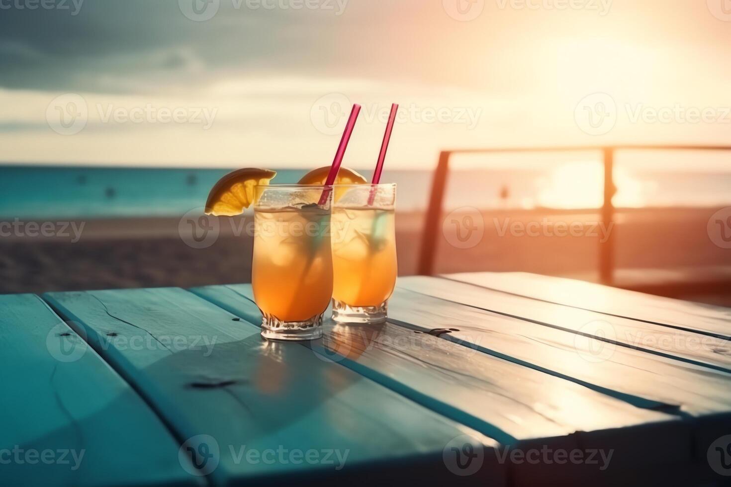 Wooden table and glasses with cocktails in the eground and soft focus summer beach and a bar in the blurred background tropical resort banner as a tropical holiday concept. photo