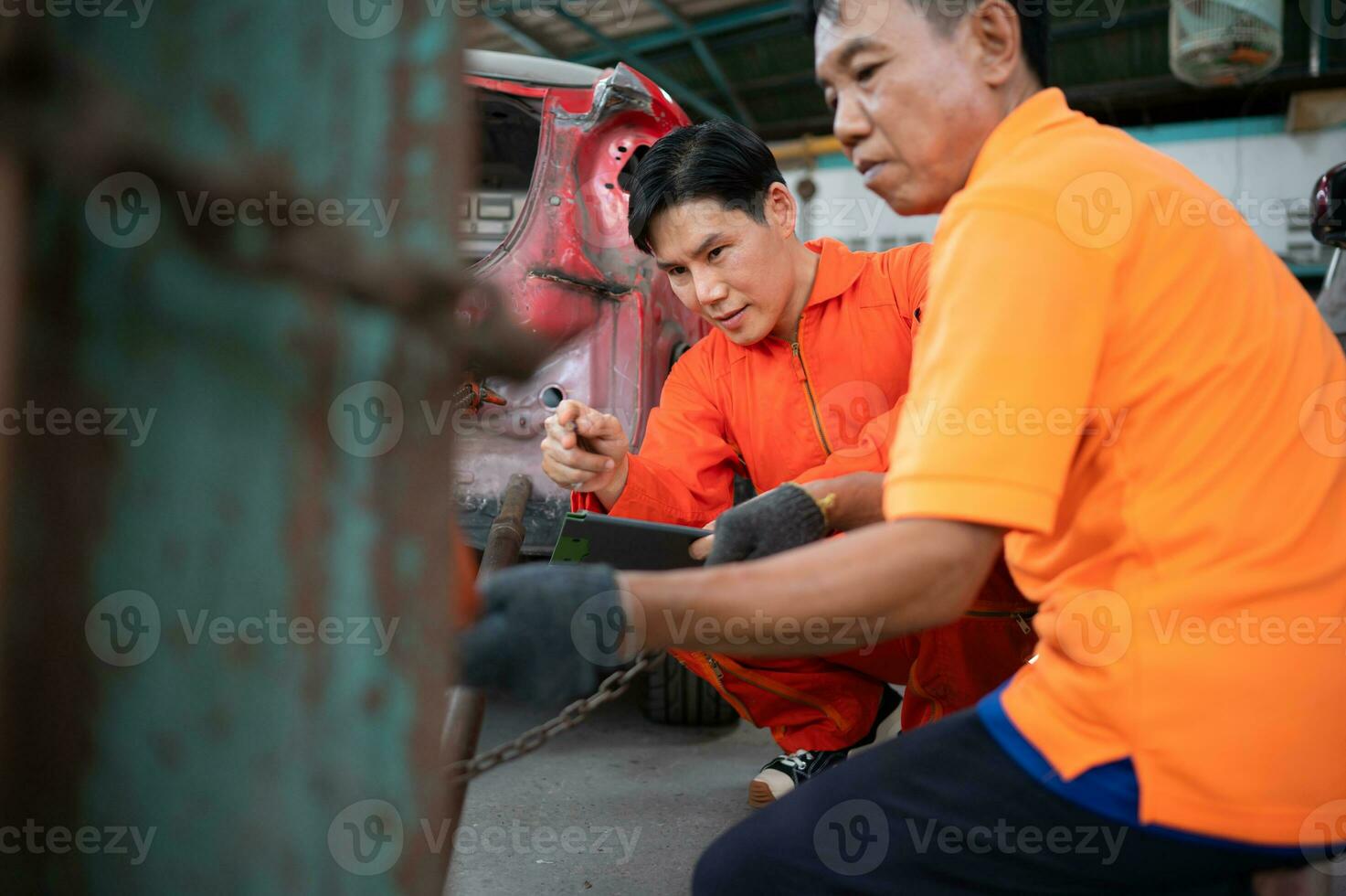 To return the automobile body to its former shape, an auto repair mechanic uses a machine to pull the car body caused by a heavy collision until it is deformed. photo