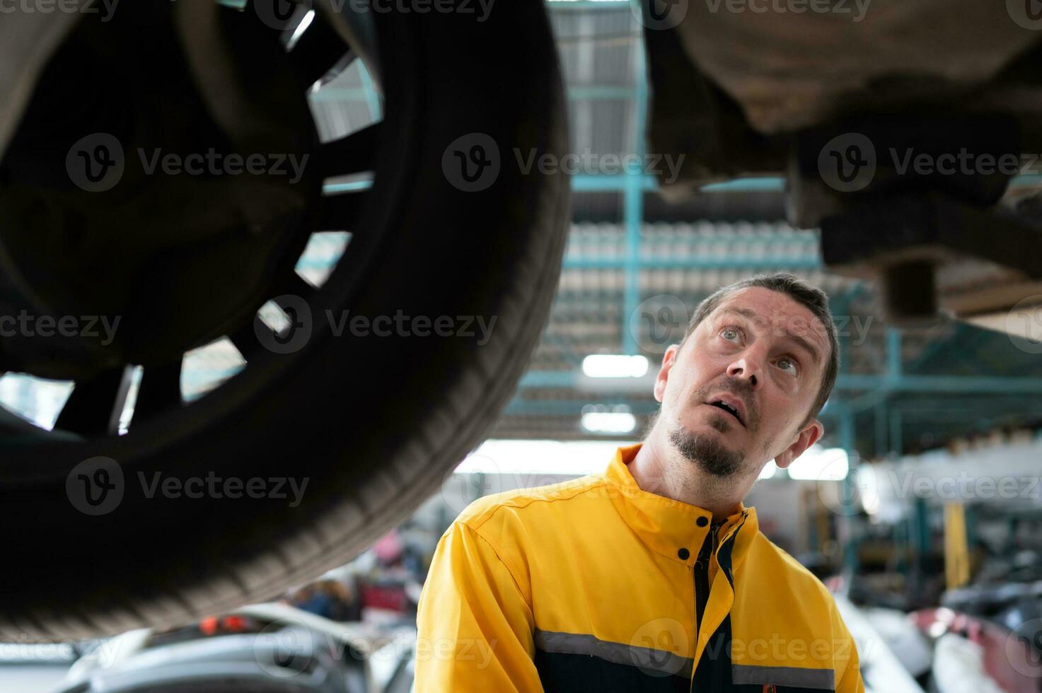 Auto repair mechanic the undercarriage of the car is being inspected for damage caused by heavy collisions. photo