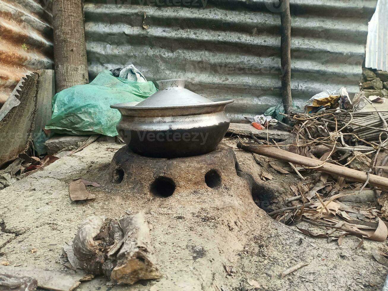 Rural kitchen. Traditional stoves used by residents in rural India, made of clay, fueled with wood, Cooking Food On Soil Stove With Dry Leafs And Wood In Village photo