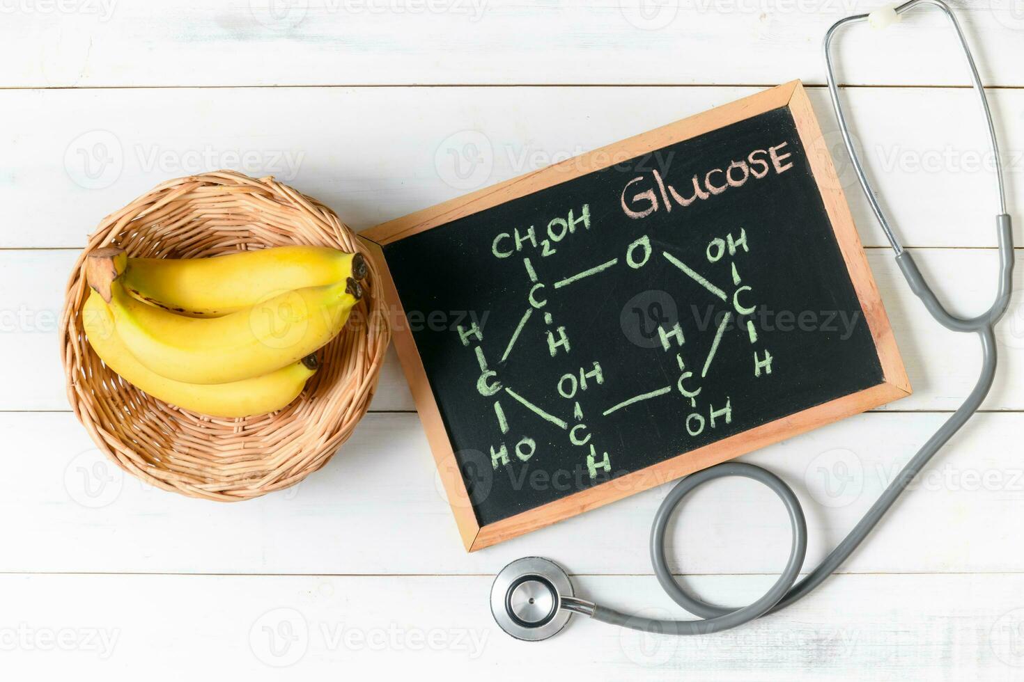 Glucose molecule on blackboard with banana and stethoscope photo