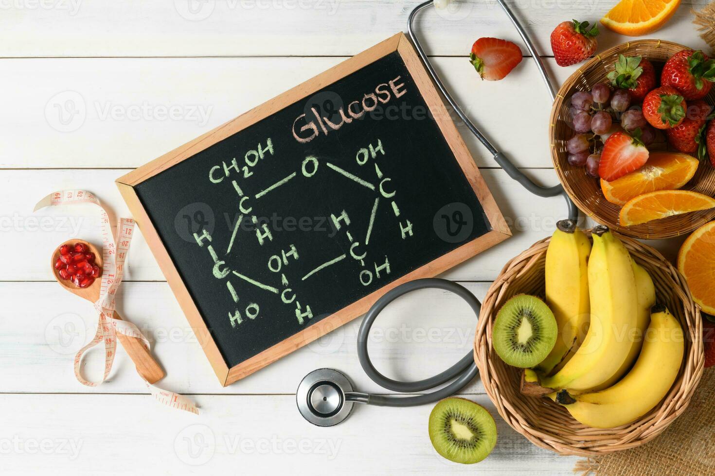Glucose molecule on blackboard with mixed fresh fruits photo