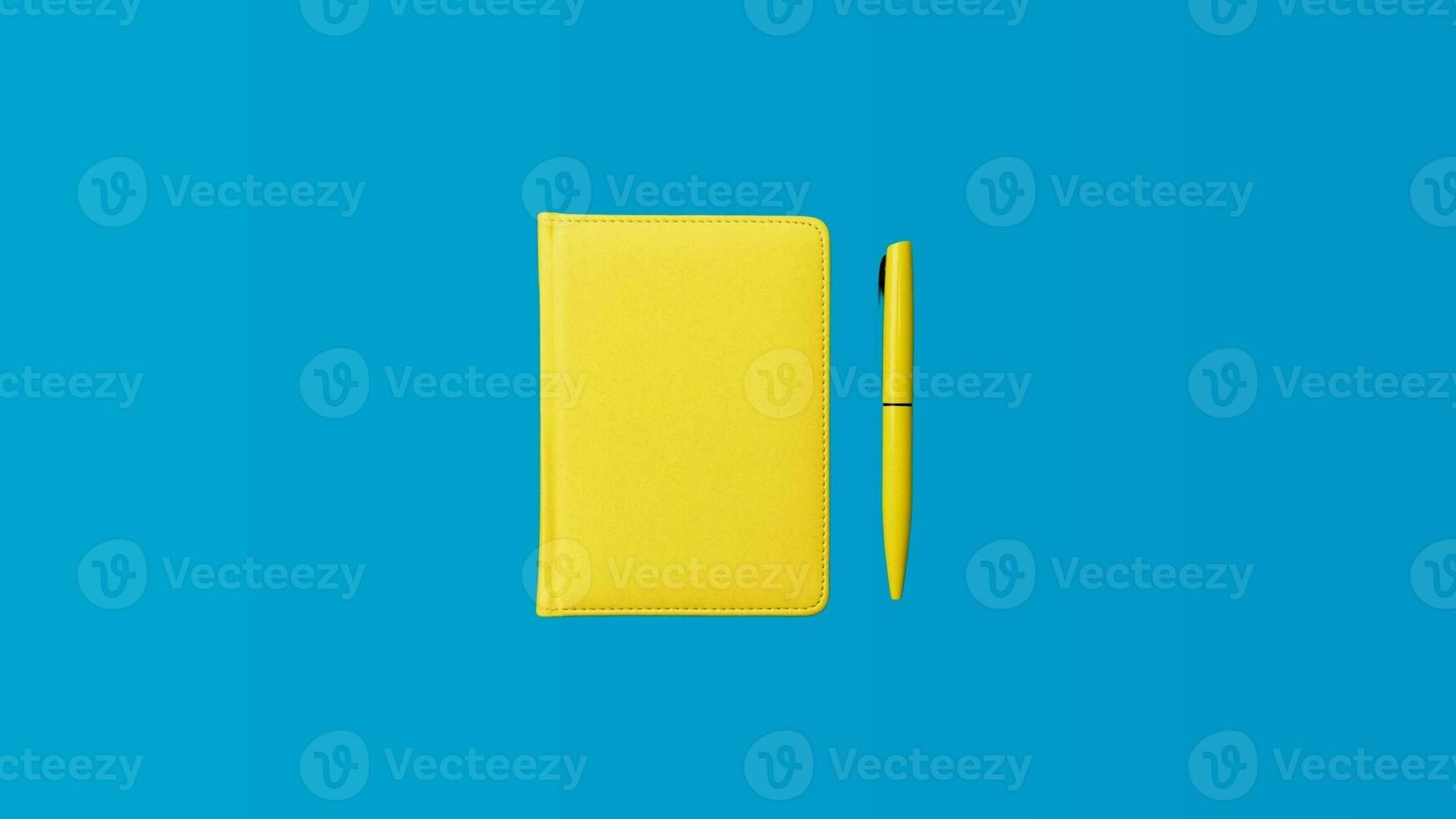 Photo of closed yellow notebook and ball-point pen over blue background. Minimalist image of closed diary and yellow pen as back to school concept.