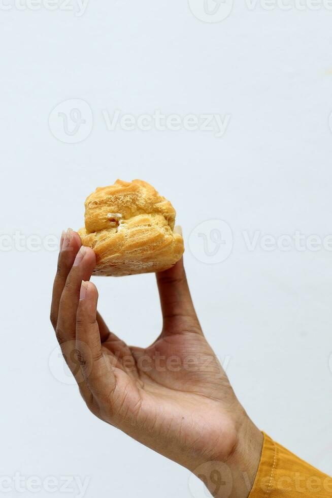 Female Hand Hold Vanilla Custard Soes Choux photo