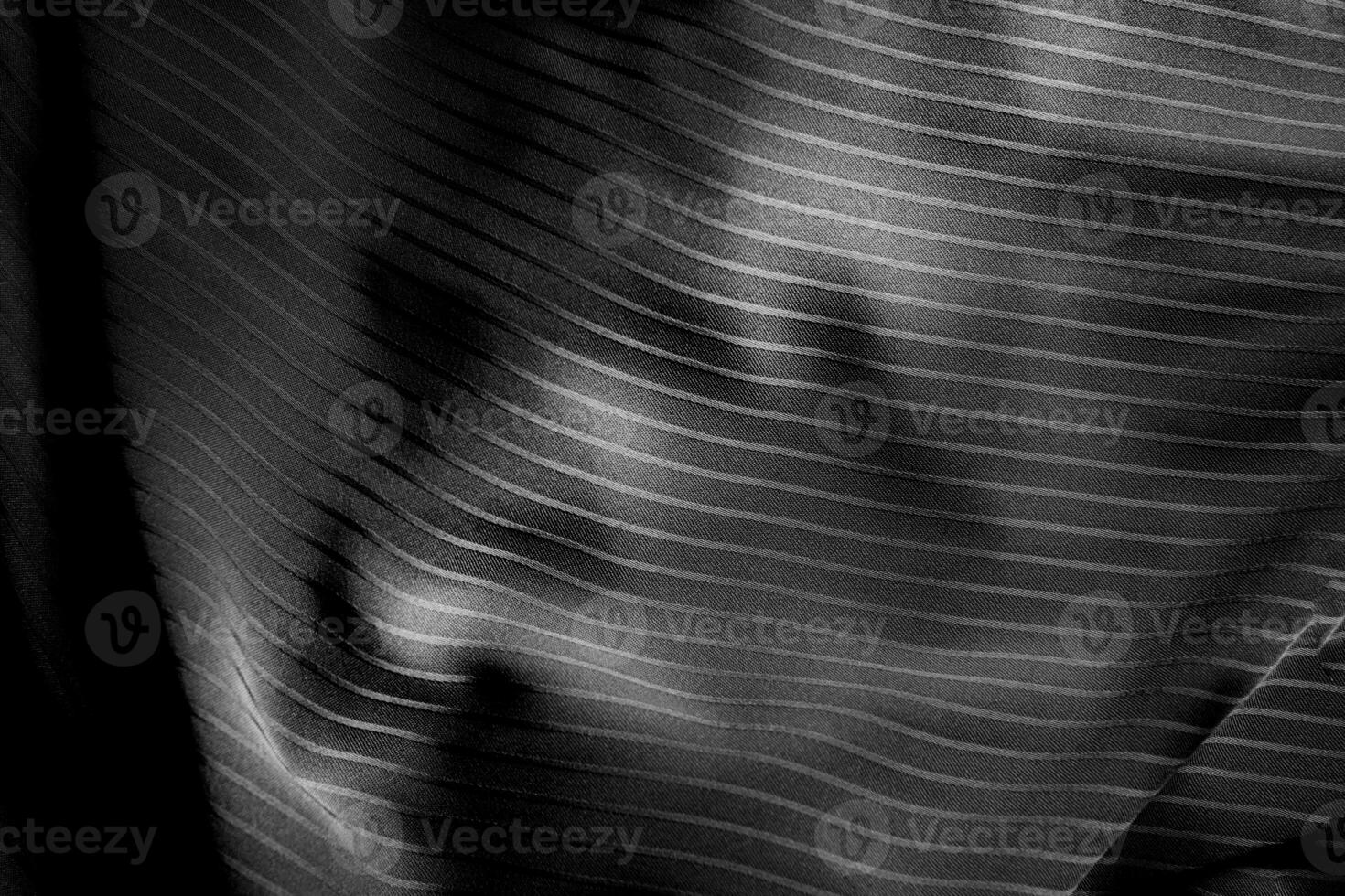 Dark black and gray blurred gradient and line of cloth or fabric background has a little abstract light. photo