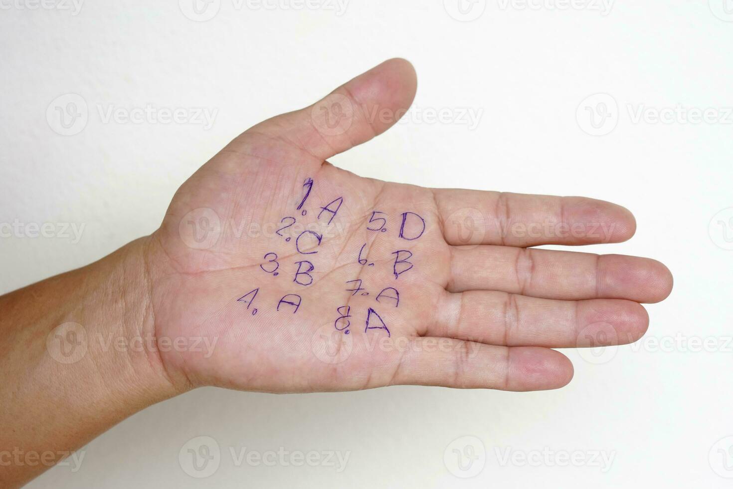 Closeup hand with written numbers and letters .Student write answer on palm. Concept , cheat the test. Dishonest behaviour. Education assessment. photo