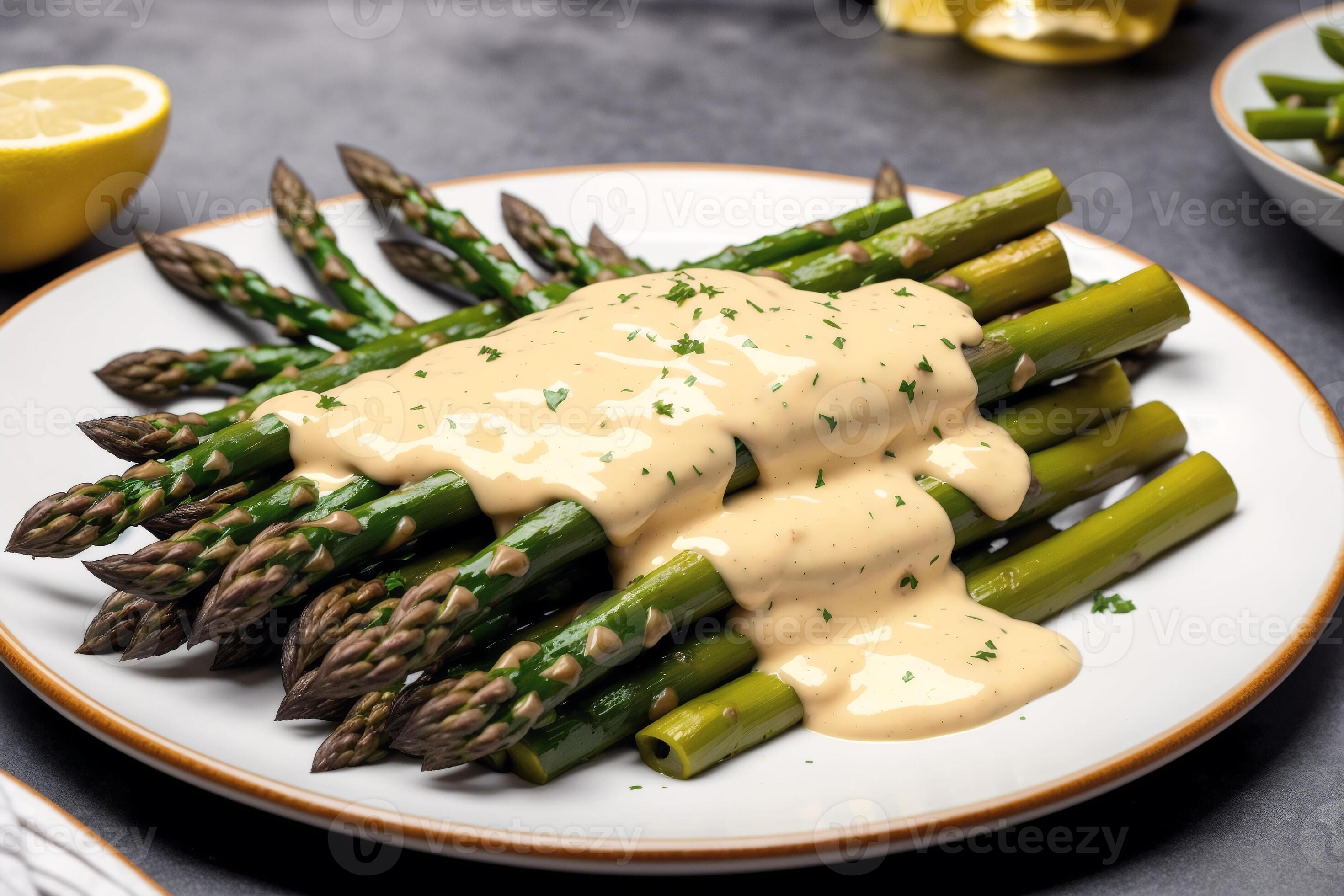 Asparagus with hollandaise sauce on a white plate, closeup. Healthy