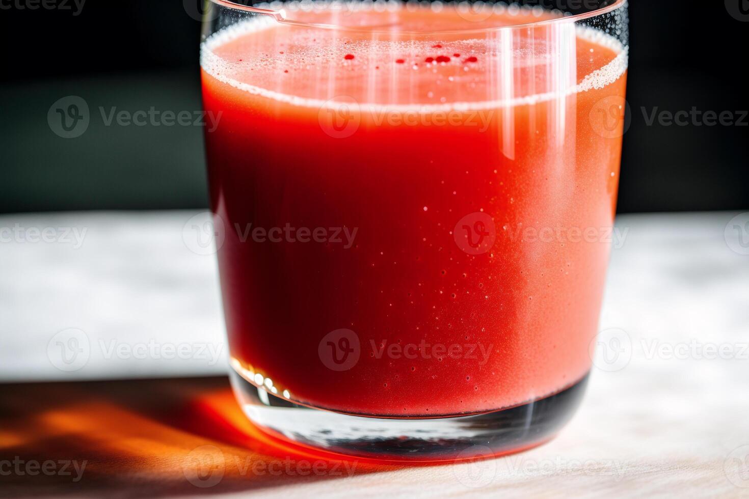 Fresh Tomato juice in a glass on a wooden background, closeup. Healthy food concept. photo