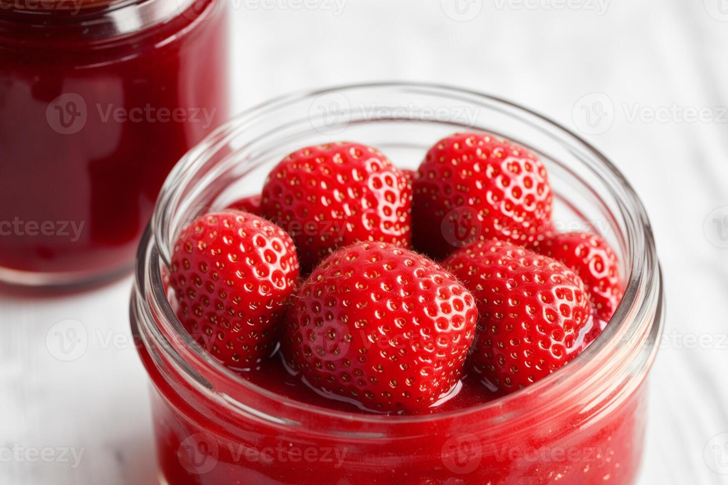 Strawberry jam in a glass jar with fresh strawberries, closeup. Healthy food concept. photo