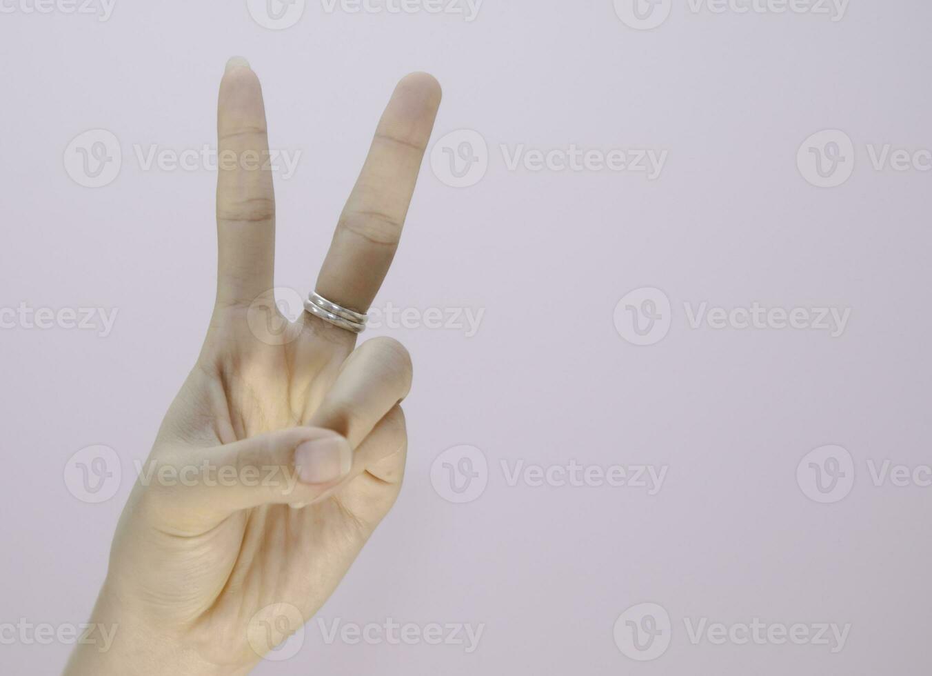 closeup woman hand showing two fingers sign language isolated on white background photo